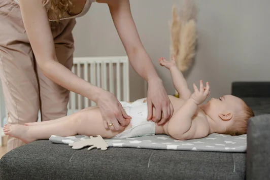 Parent changeant la couche de son bébé sur une table à langer